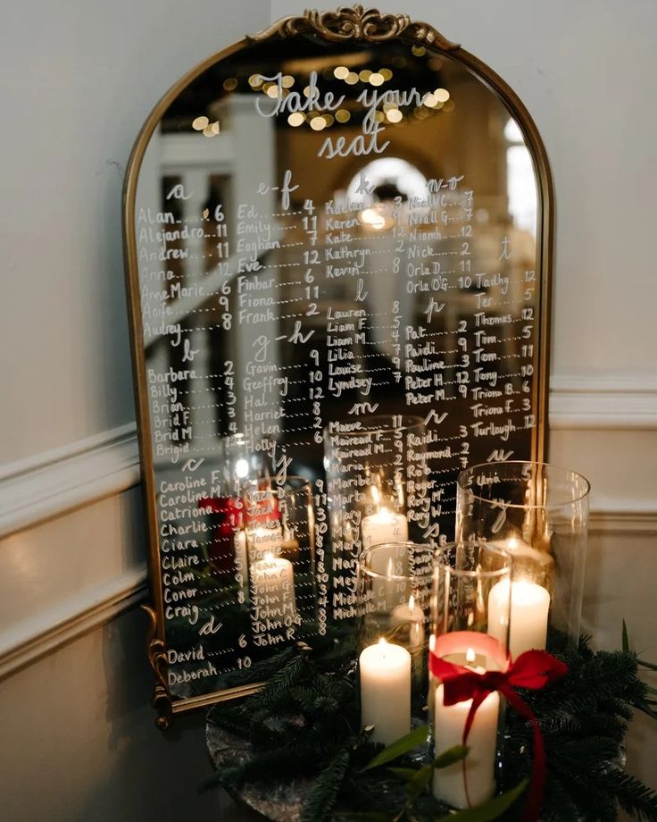 candles are lit in front of a mirror with writing on it