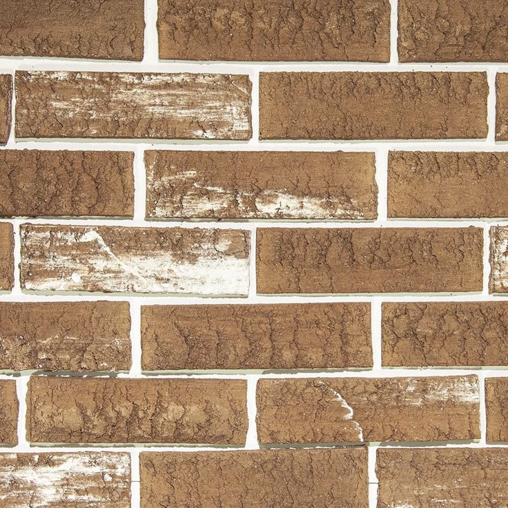 an old brick wall with white paint and brown bricks on the bottom half of it