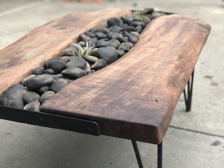 a wooden bench with rocks and plants in it