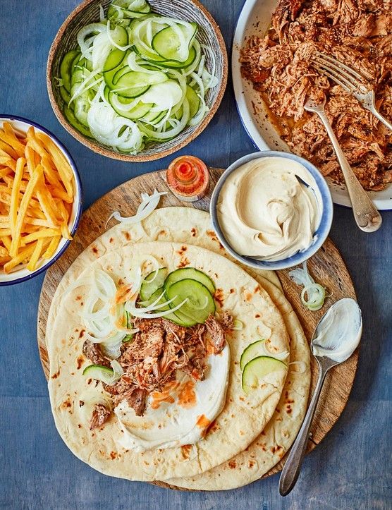 an assortment of food including tortillas, meat and vegetables