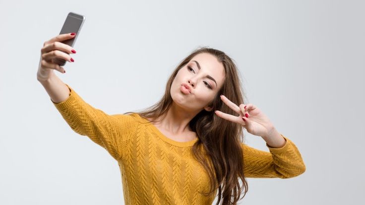 a woman is holding up her cell phone