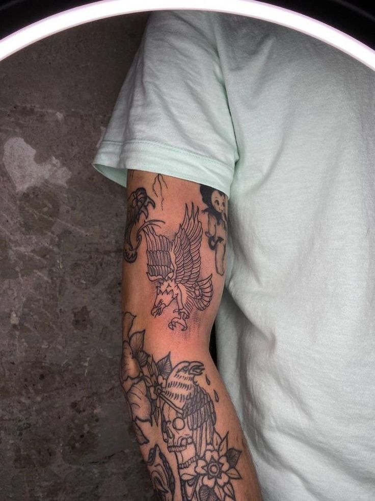 a man's arm with tattoos on it and an eagle in the middle of his arm