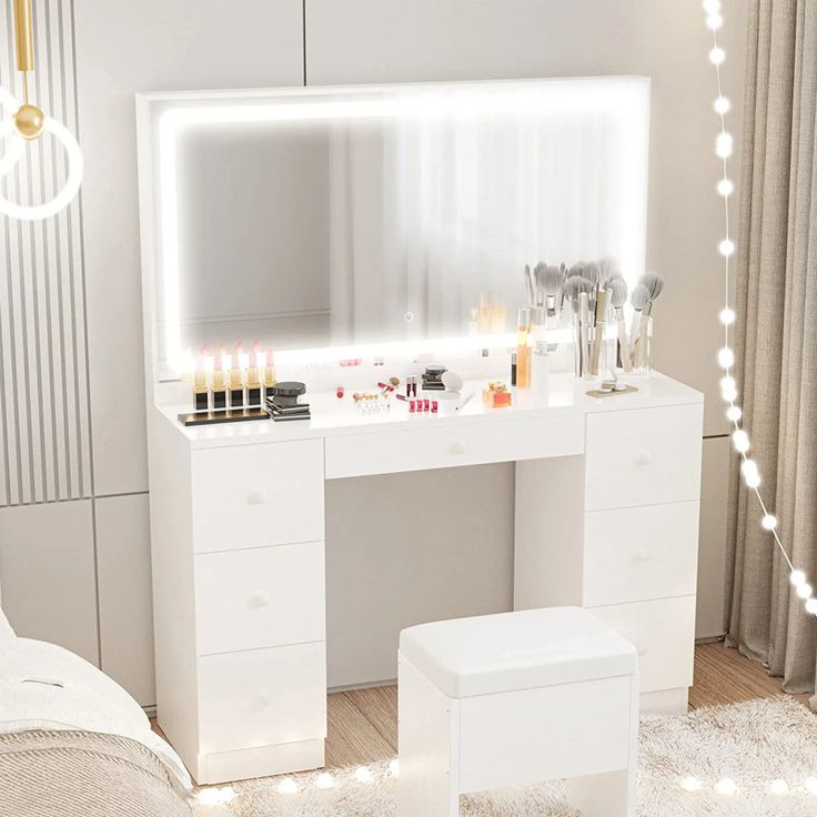 a white vanity with lights on it in a bedroom