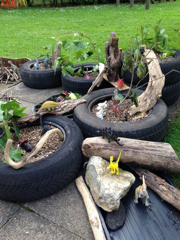 there are many tires that have been placed on the ground with plants growing out of them