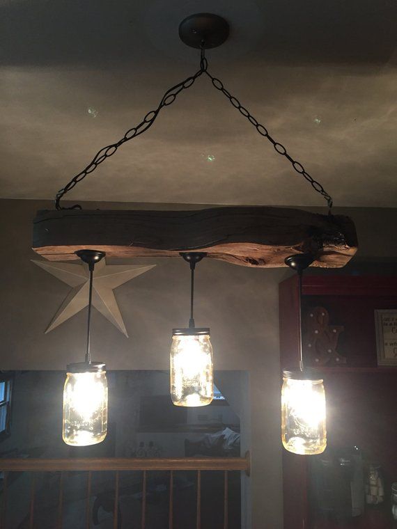 three mason jar lights hanging from the ceiling in a bar or restaurant with stars on them