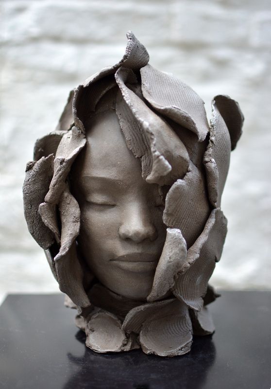 a sculpture of a woman's head has been made out of clay