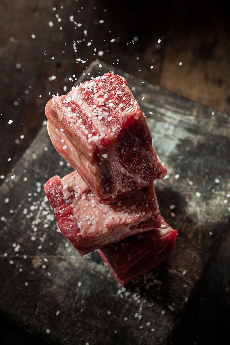 raw meat on a cutting board with salt sprinkled around it's edges