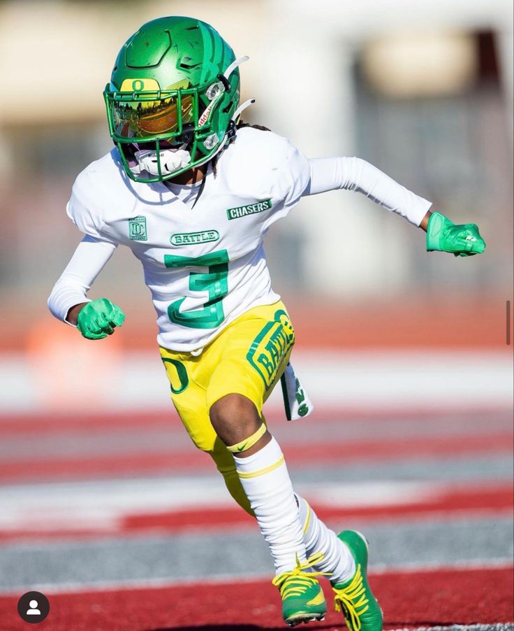 a football player wearing green and yellow running on the field