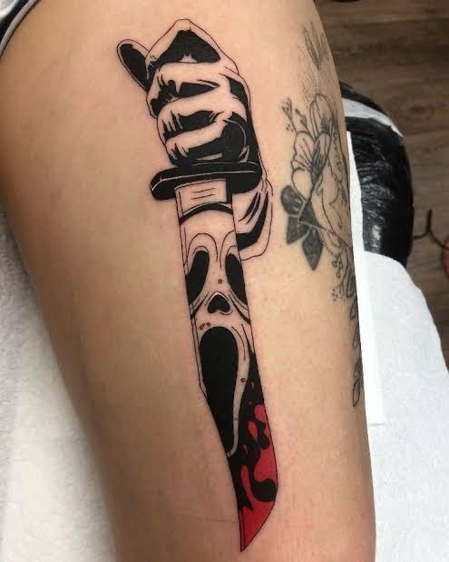 a tattoo on the arm of a person with a knife in it's hand