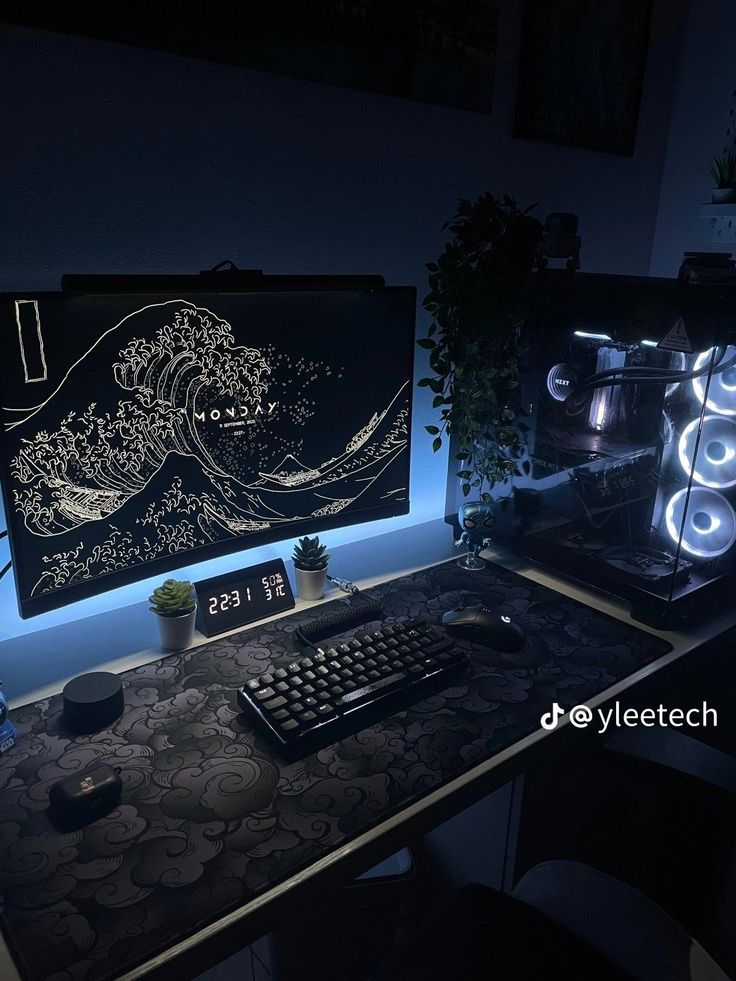 a desk with a keyboard and monitor lit up in the dark by lights on it