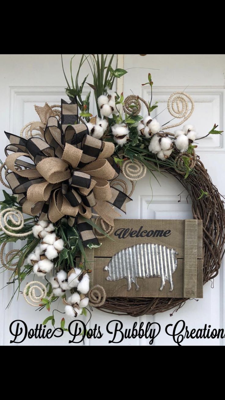 a wreath with cotton flowers and a football on it is hanging from the front door