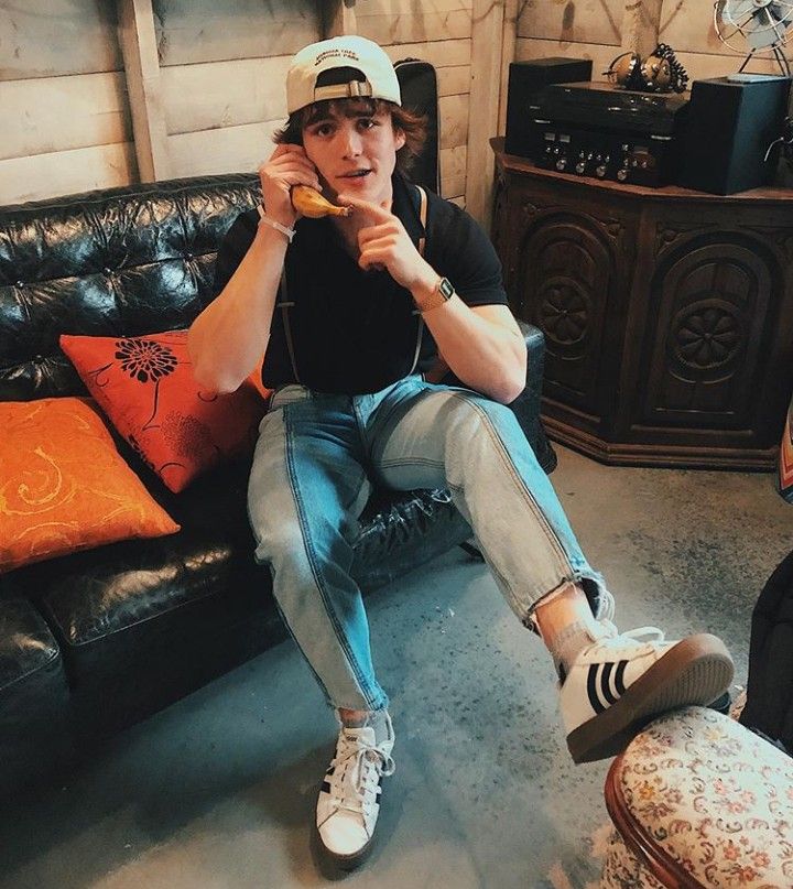 a young man sitting on a couch eating food