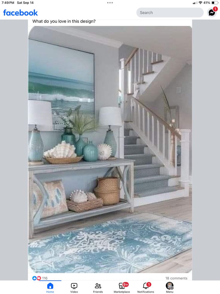 a living room with blue and white decor on the walls, stairs and rugs