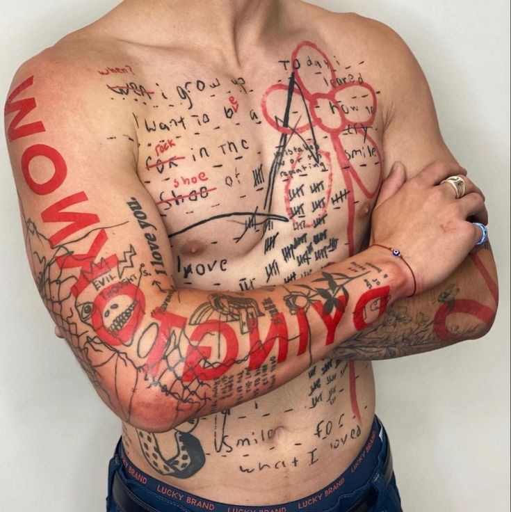 a man with tattoos on his chest and arms