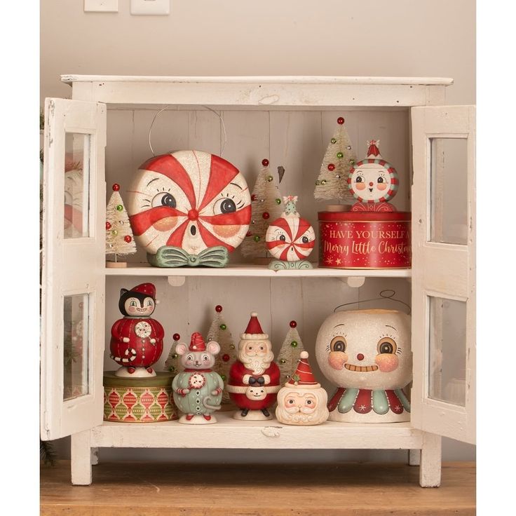 a white shelf filled with lots of christmas decorations