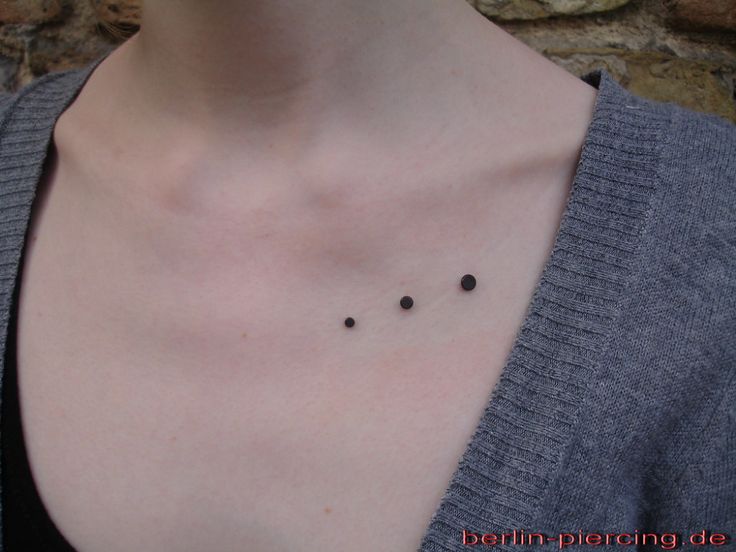 a woman with small black dots on her chest