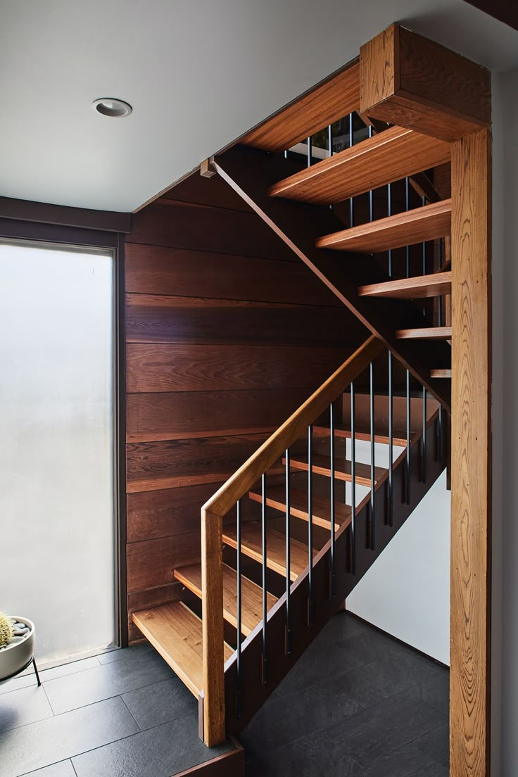 a wooden stair case next to a glass door