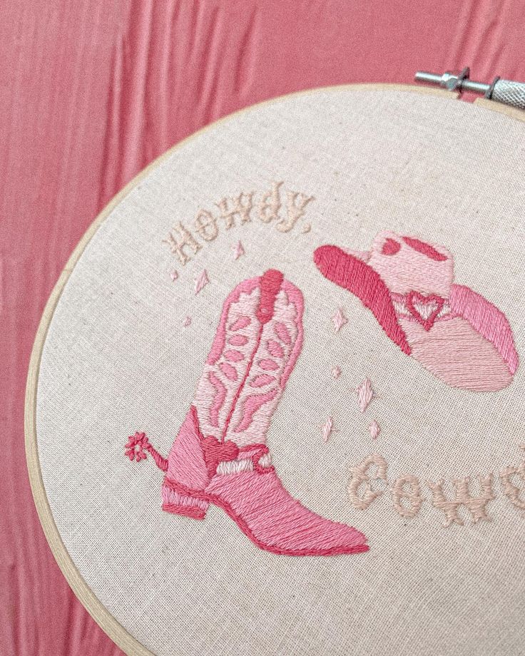 a close up of a embroidery on a piece of cloth with the words happy new born and cowboy boots