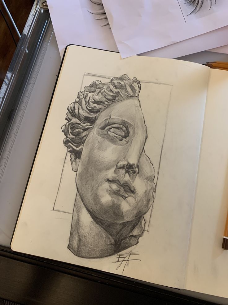 an open book with a drawing of a man's head on top of it