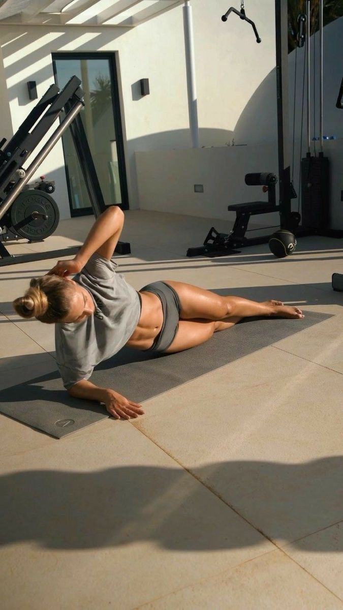 a woman laying on the ground in front of a gym equipment line with her legs spread out