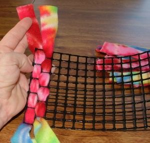 someone is holding up some colorful tie - dyes on a table with a wire rack