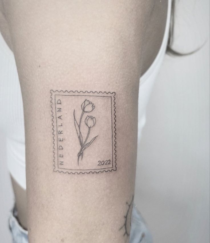 a stamp with a flower tattoo on the back of a woman's left arm