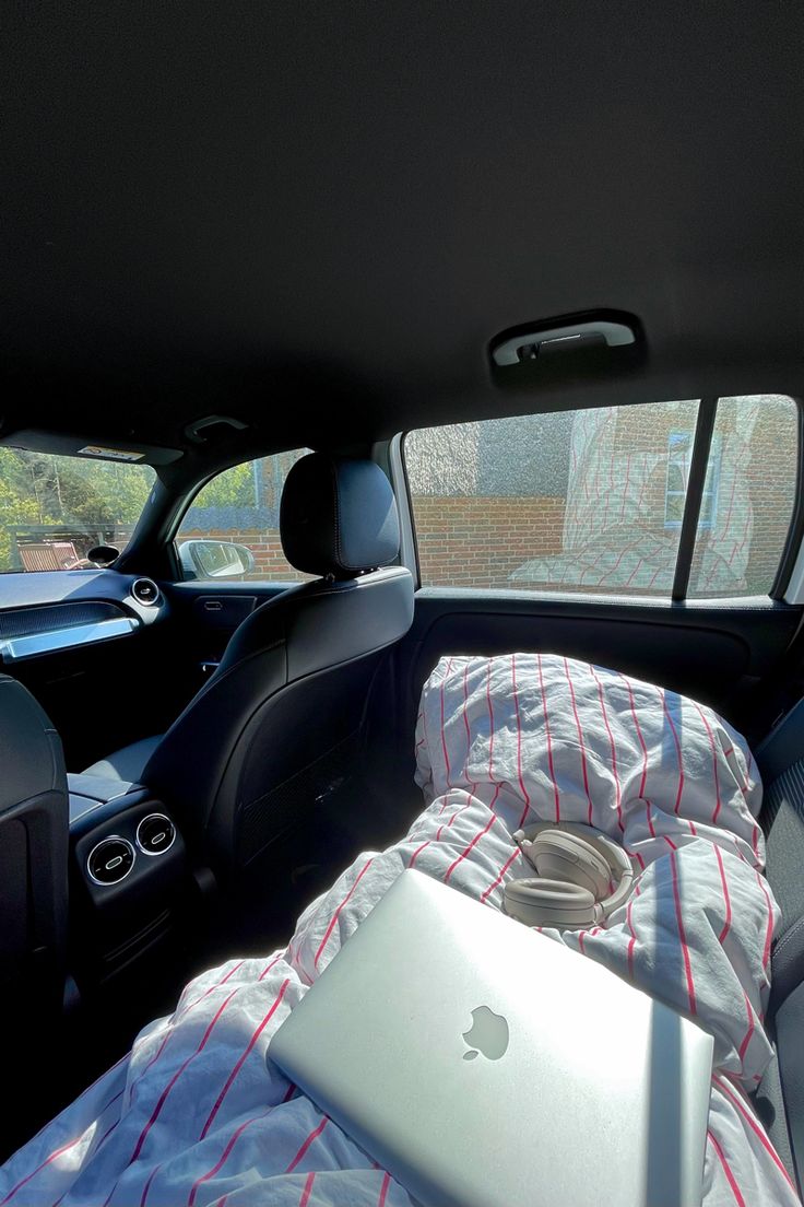 an open laptop computer sitting in the back seat of a car