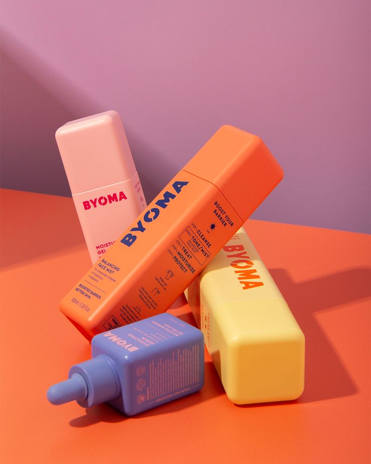 three different types of toothpaste on an orange table with pink and purple background