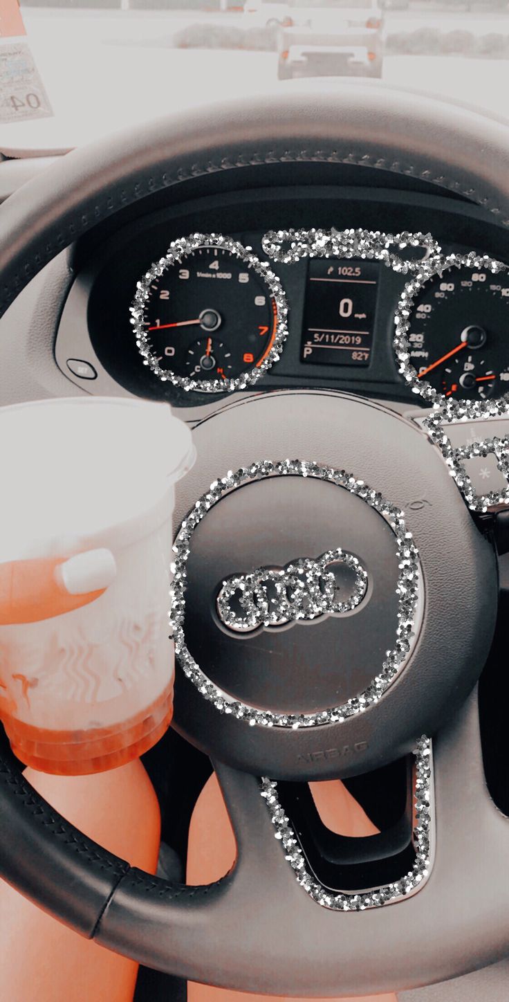 the steering wheel and dash board of a car decorated with silver sequins is shown