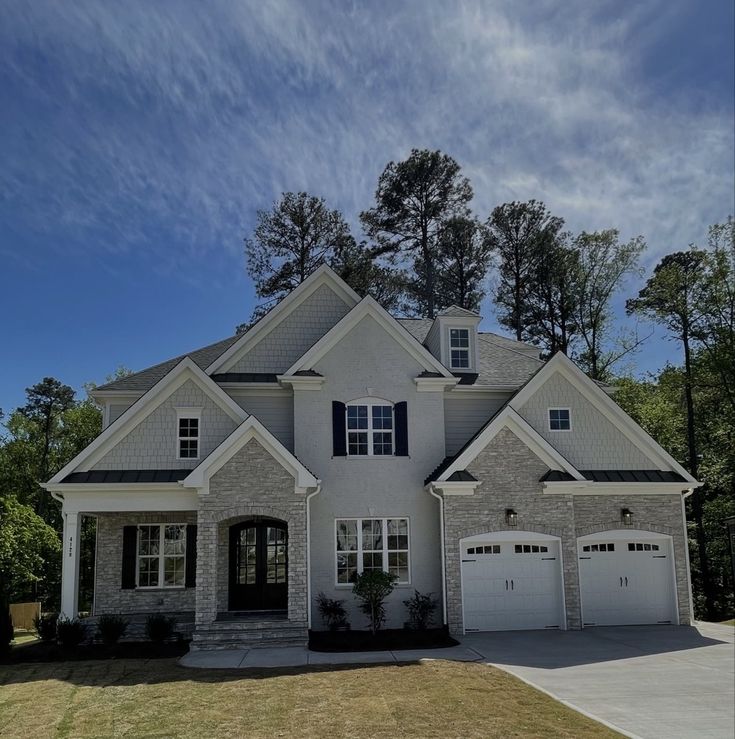 a large white house with two garages in the front yard