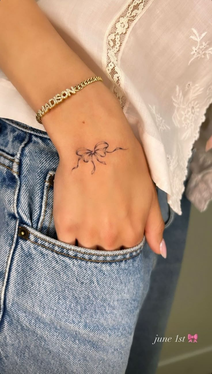 a woman's hand with a small tattoo on it