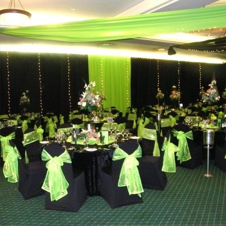 a banquet hall decorated with green and black tables, chairs, and centerpieces