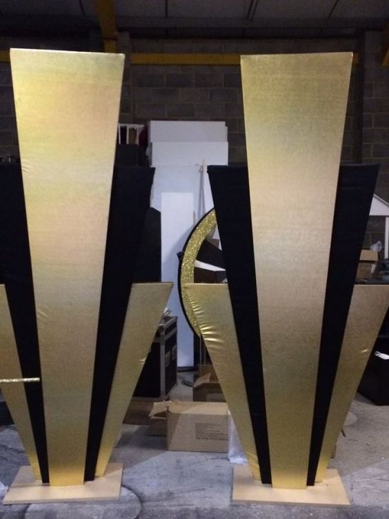 two large black and gold vases sitting on top of each other in a room