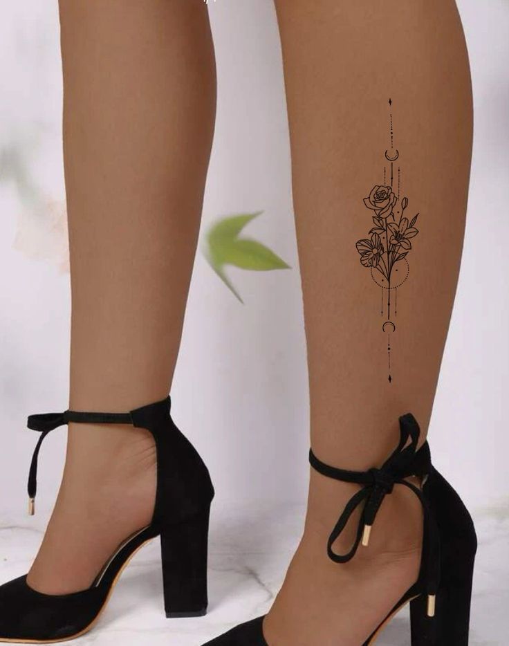 a woman's legs with tattoos and heels on her feet, one has a flower tattoo