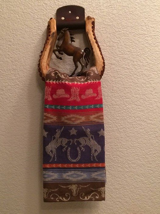 a towel holder with a horse on it hanging from the side of a white wall