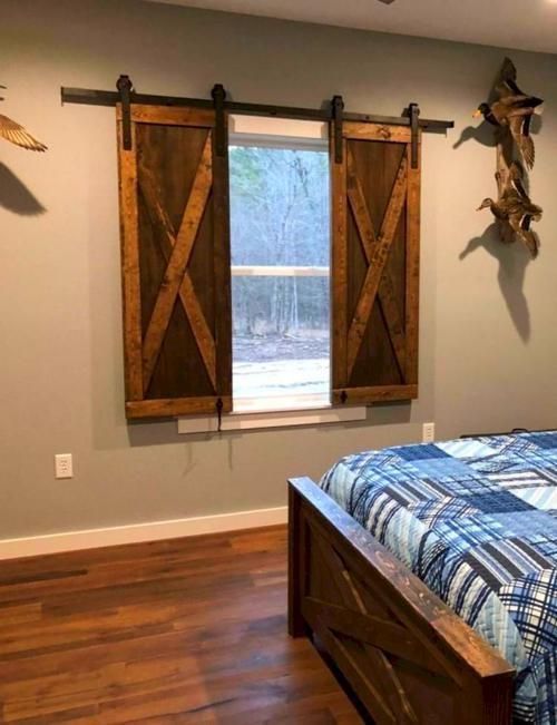 a bedroom with a bed and two wooden barn doors hanging on the wall above it