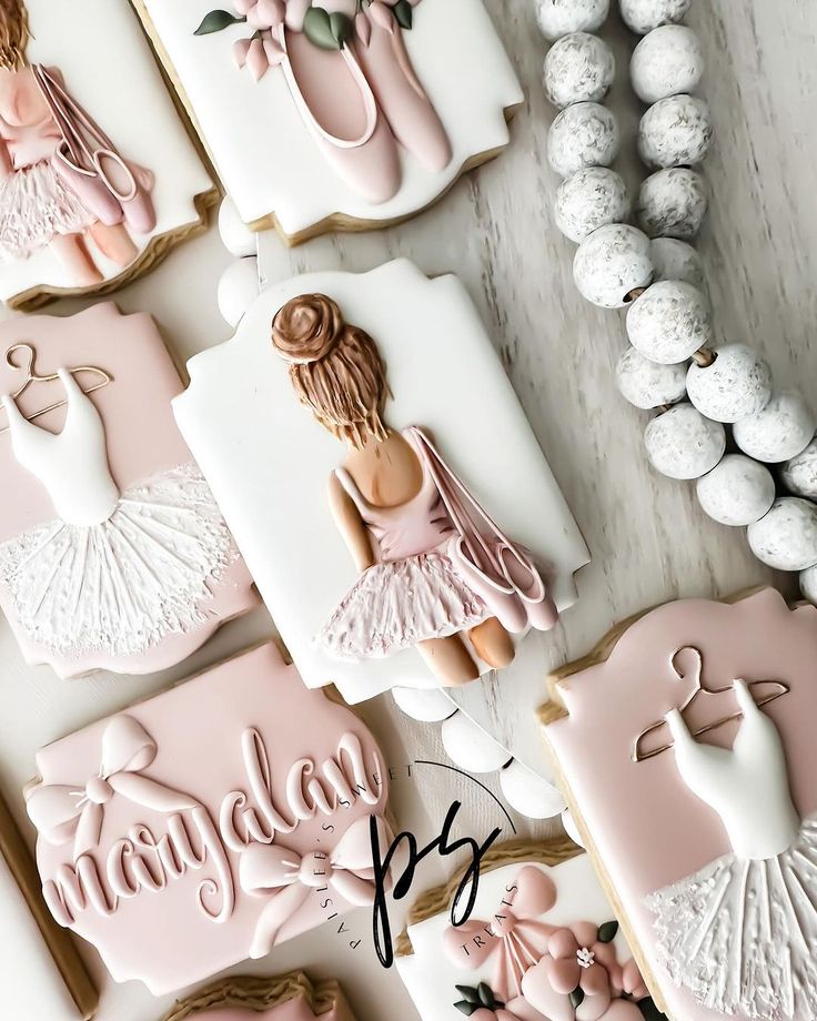 decorated cookies are displayed on a table with beads and other items in the shape of ballerinas