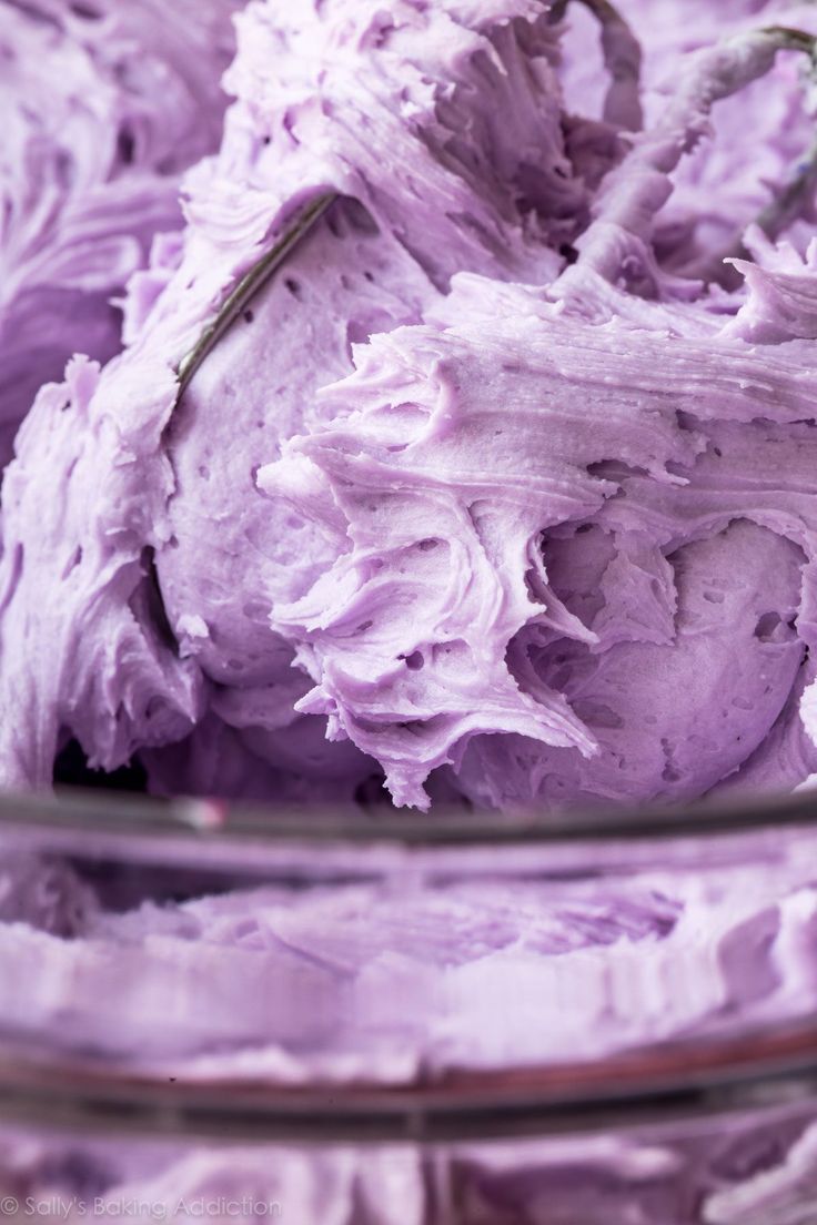 a bowl filled with purple frosting sitting on top of a table