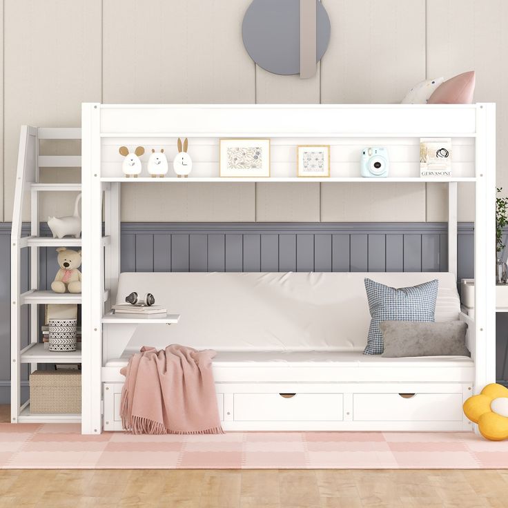 a white bunk bed sitting in a bedroom next to a wall with pictures on it