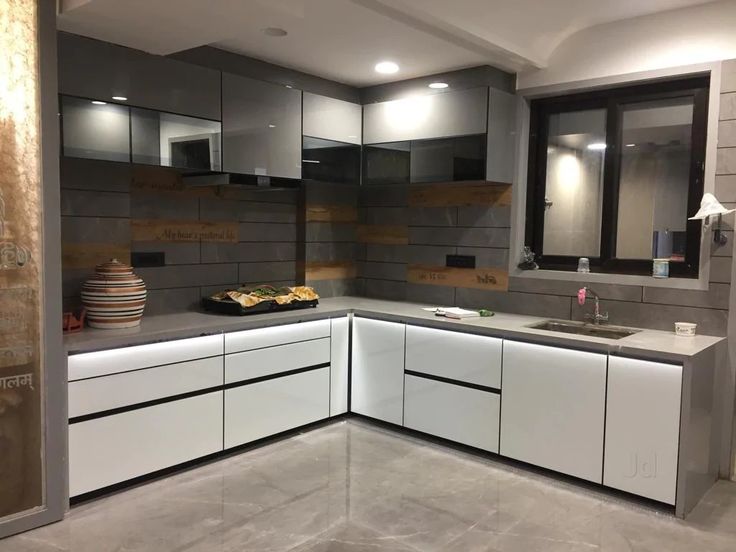 a kitchen with white cabinets and grey counter tops