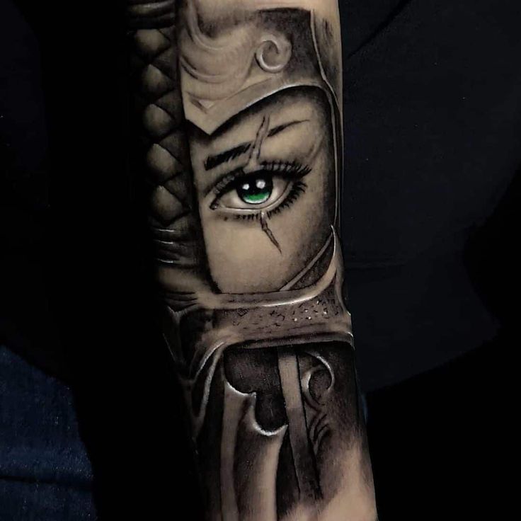 a woman's arm with an evil face and green eyes