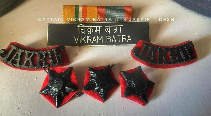 three red and black star badges on top of a white table with a sign that says, captain william batty 3 tamiri desh