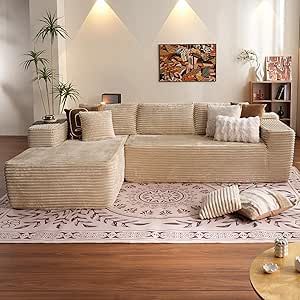 a living room with couches and pillows on the floor in front of two windows