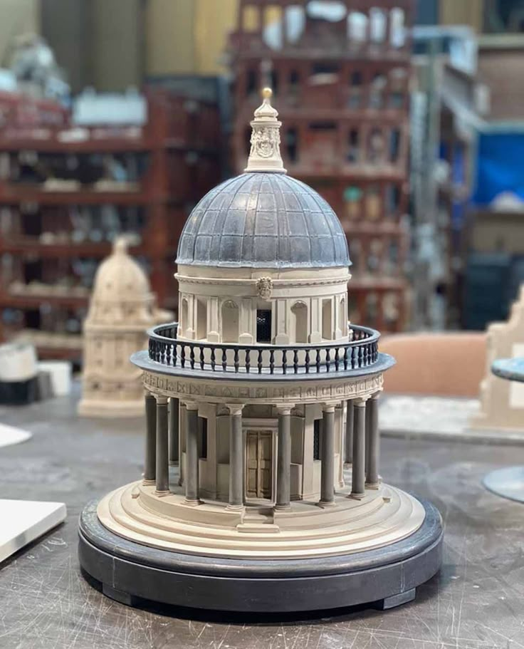 a model of a building on top of a table with other buildings in the background