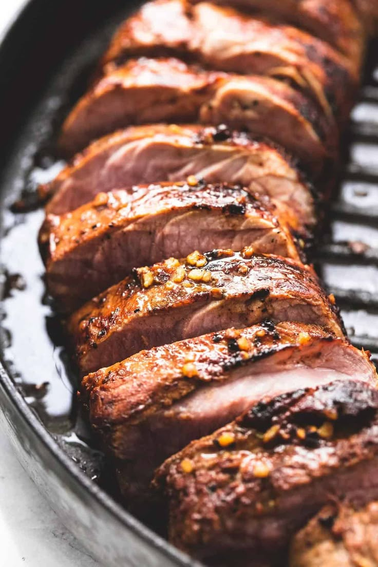 sliced meat is being cooked on the grill