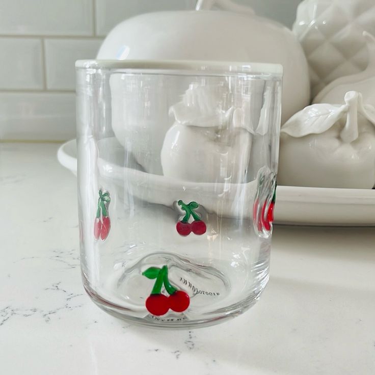 a glass cup with cherries painted on it