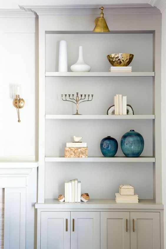 a white book shelf filled with books and vases