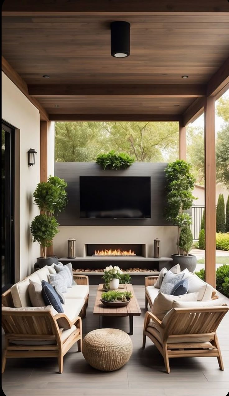 an outdoor living area with couches, chairs and a fire place in the center