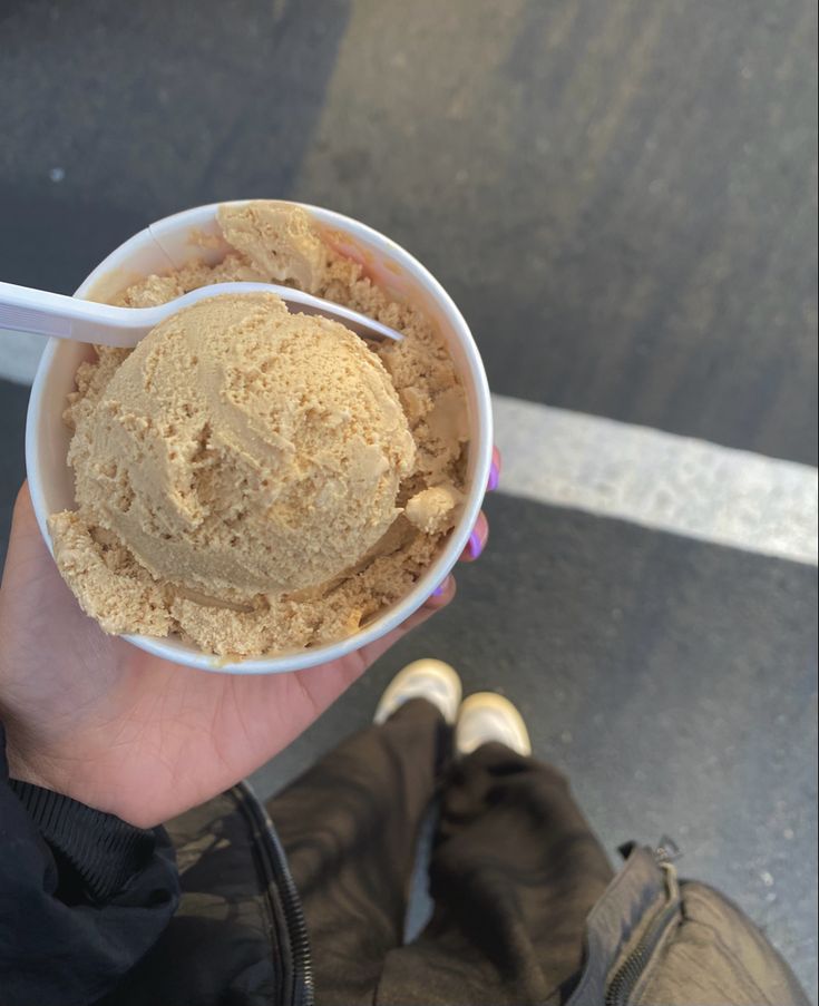 a person holding up a bowl of ice cream