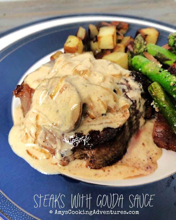 steak with gravy and asparagus on a blue plate, ready to be eaten